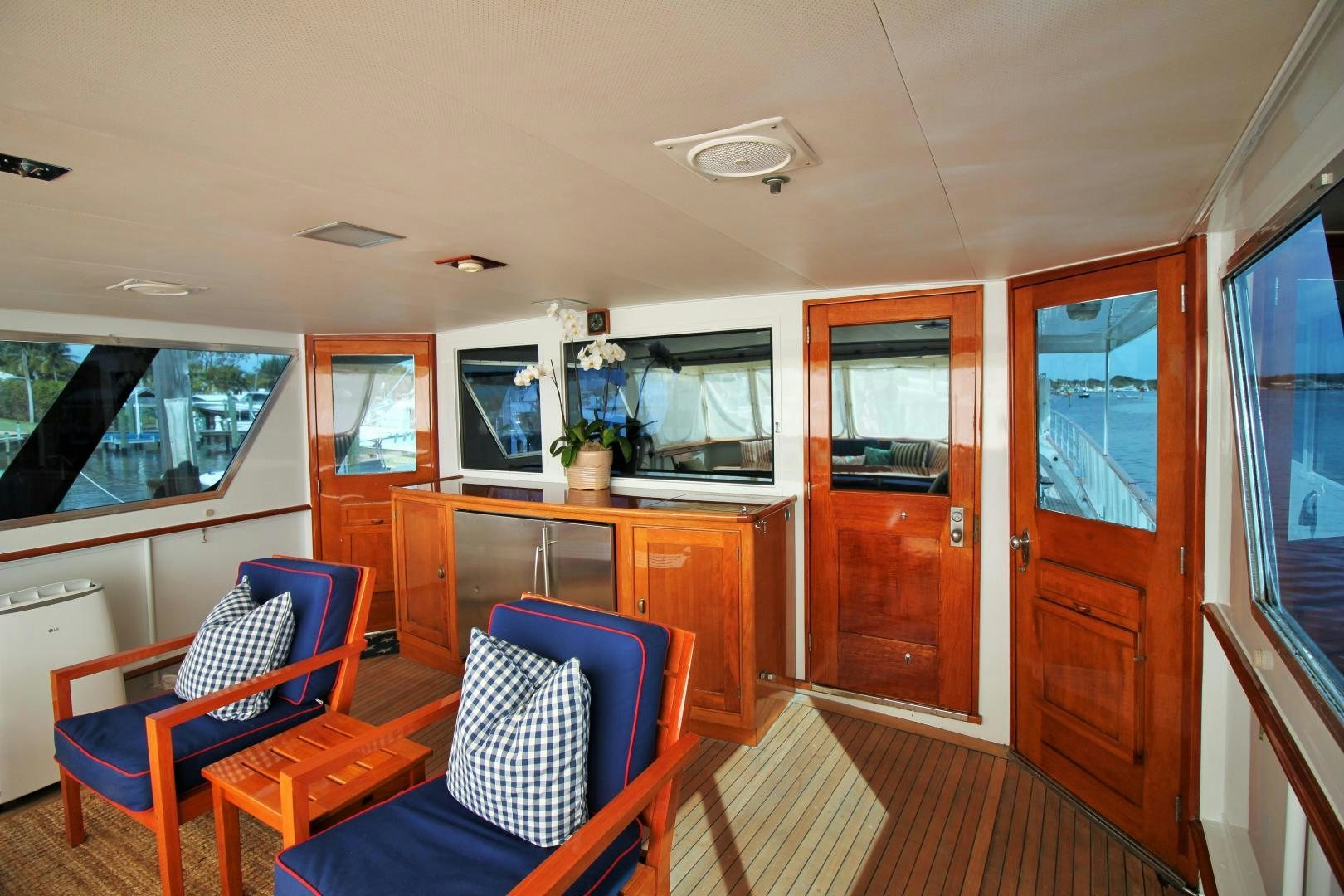 a living room with a blue chair aboard Independence Yacht for Sale