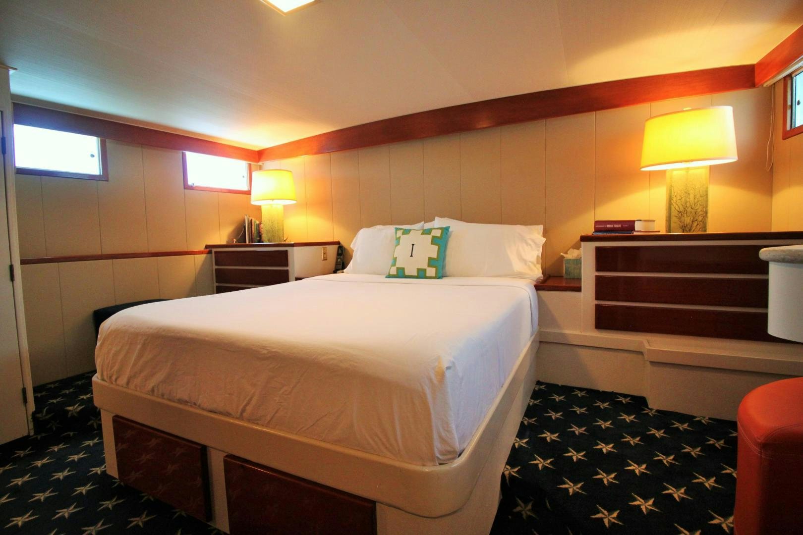 a bed with lamps on either side aboard Independence Yacht for Sale