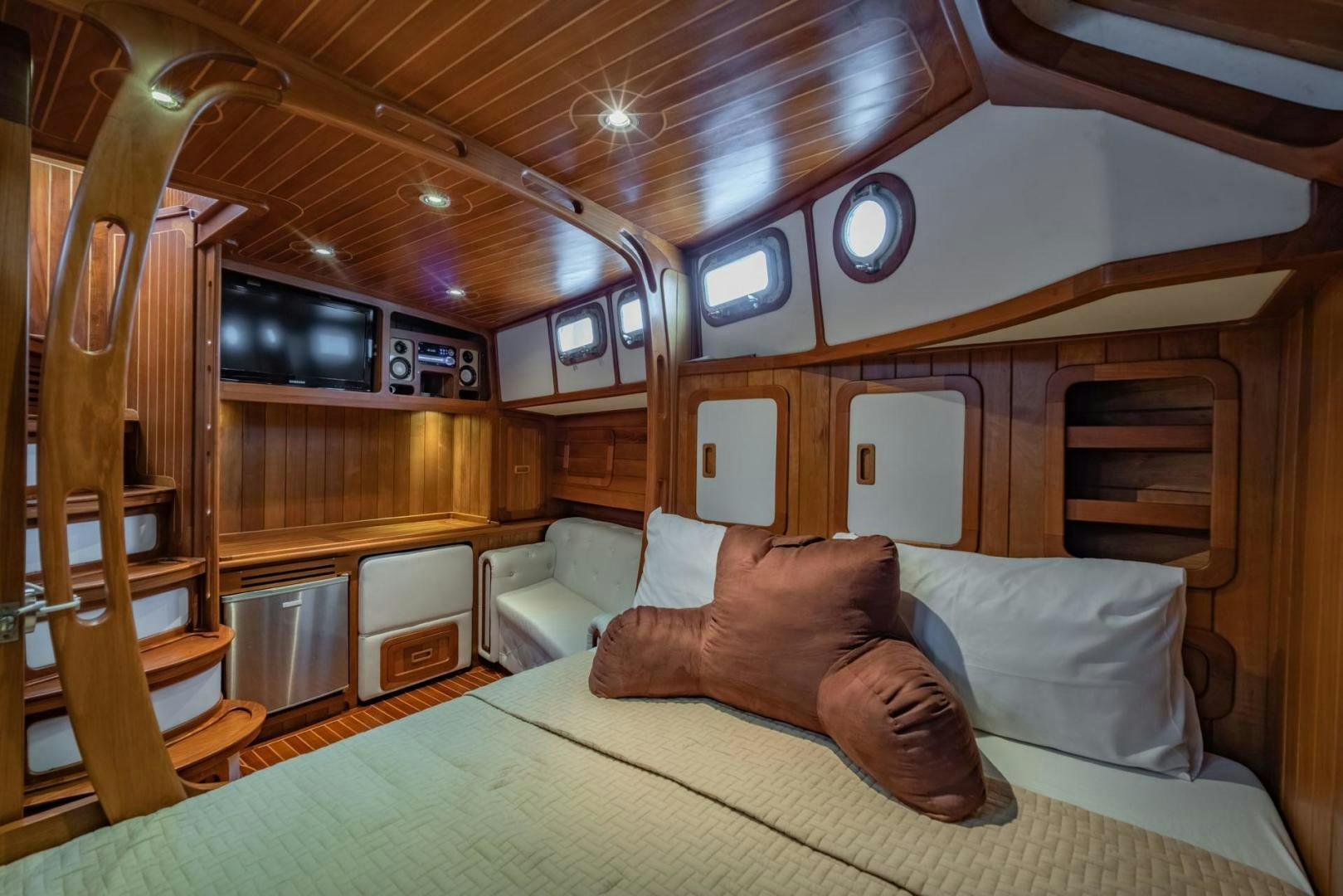a cabin with a bed and a couch aboard FIREBIRD Yacht for Sale