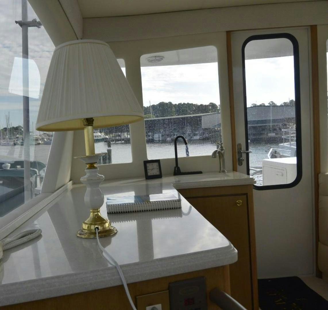 a desk with a lamp and a window aboard DOG HOUSE Yacht for Sale