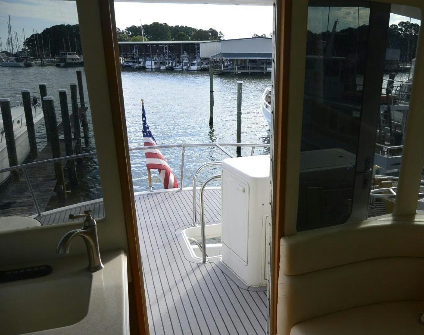 a view of a boat deck with a flag on the deck aboard DOG HOUSE Yacht for Sale
