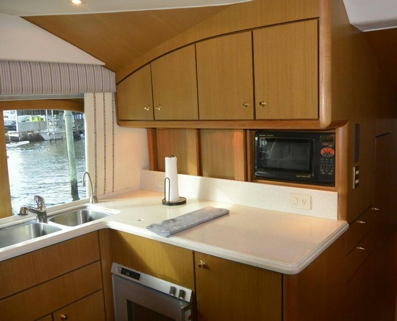 a kitchen with wooden cabinets aboard DOG HOUSE Yacht for Sale