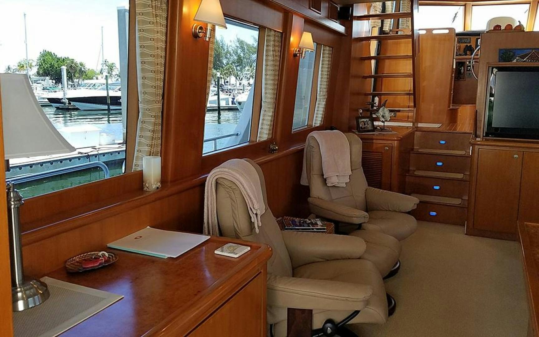 a living room with a tv and a table aboard GOWIN PLACES IV Yacht for Sale
