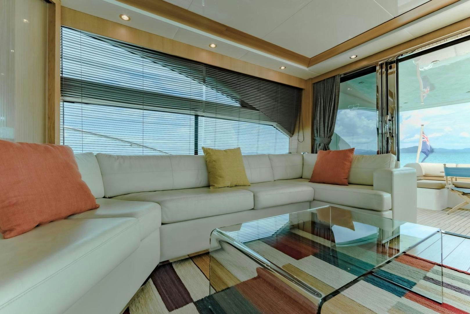 a living room with a glass coffee table and a large window aboard GIFZY Yacht for Sale