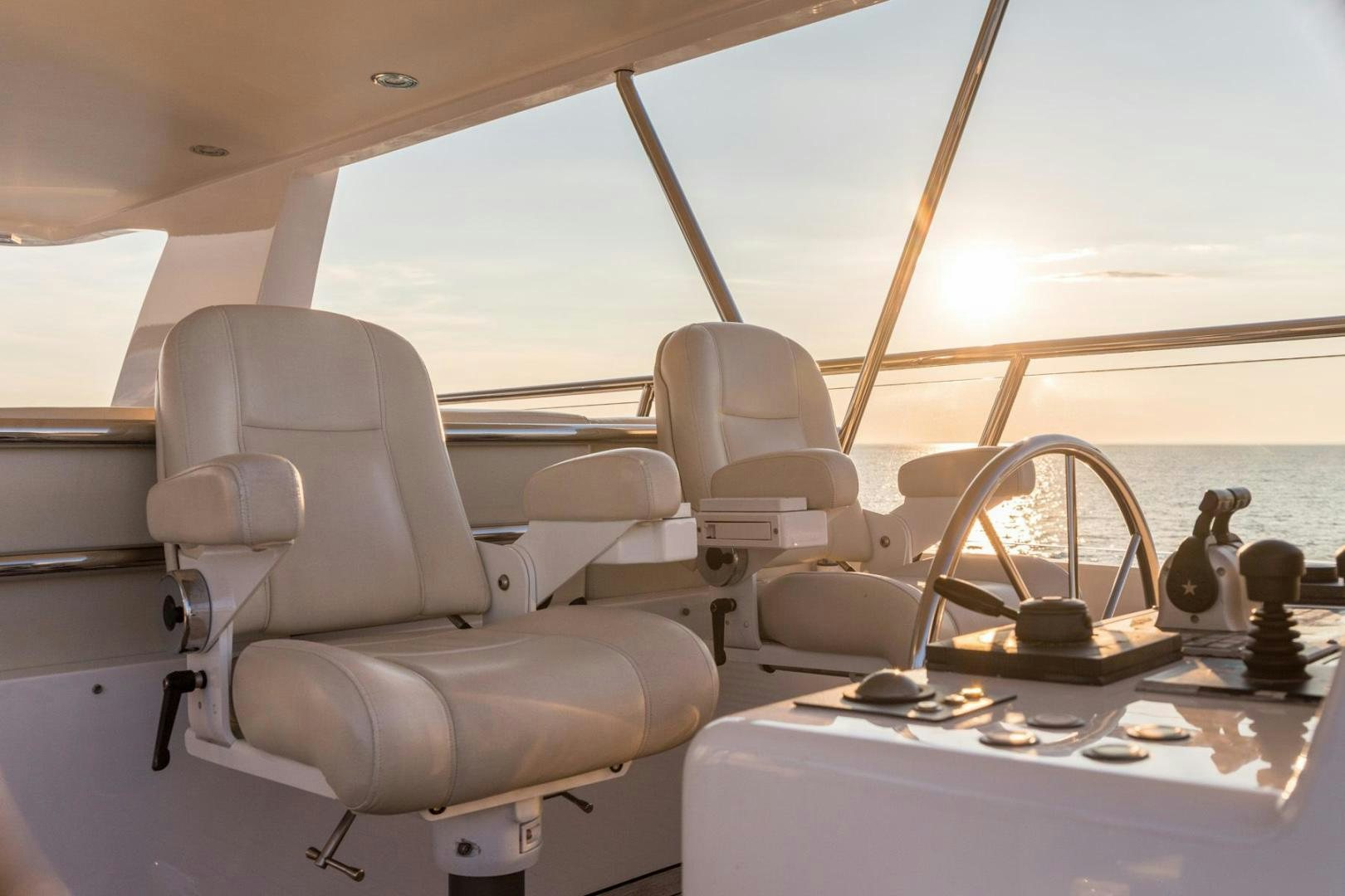 a boat with a steering wheel and chairs on it aboard PURA VIDA Yacht for Sale
