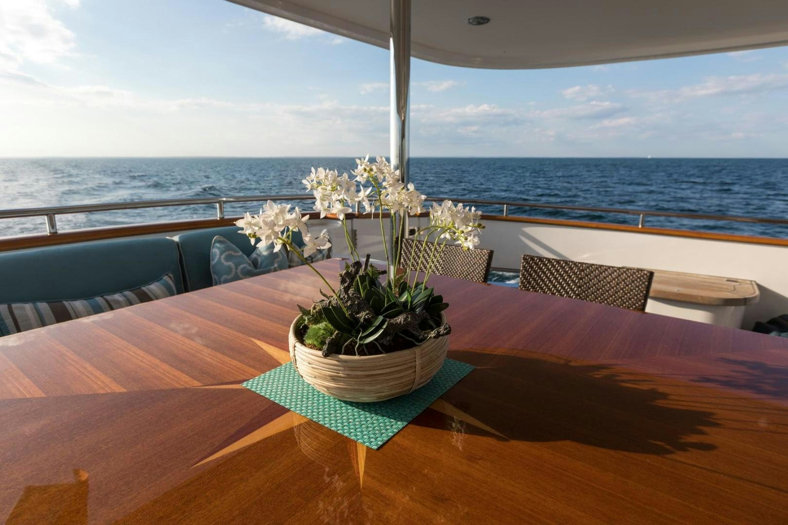 a table with a planter on it and a view of the ocean aboard PURA VIDA Yacht for Sale