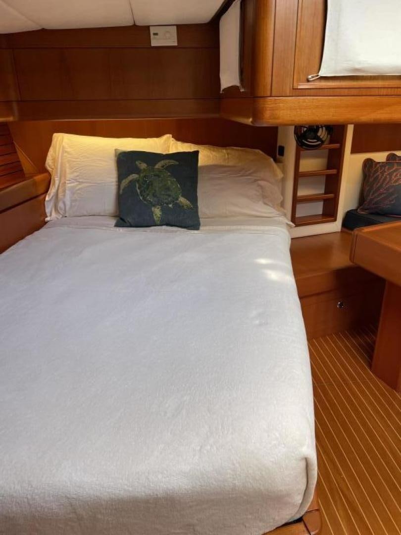 a bed with a white comforter aboard DISCO LEMONADE Yacht for Sale