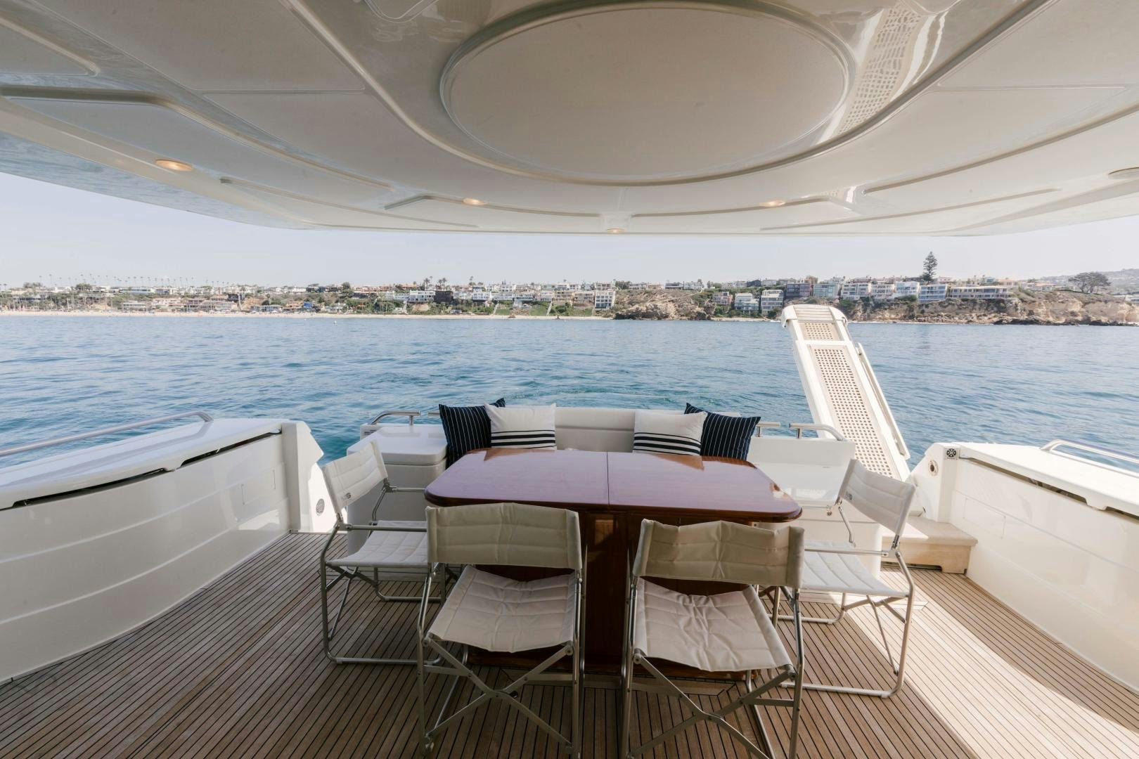 a table and chairs on a deck overlooking a large body of water aboard LIVING LIFE Yacht for Sale