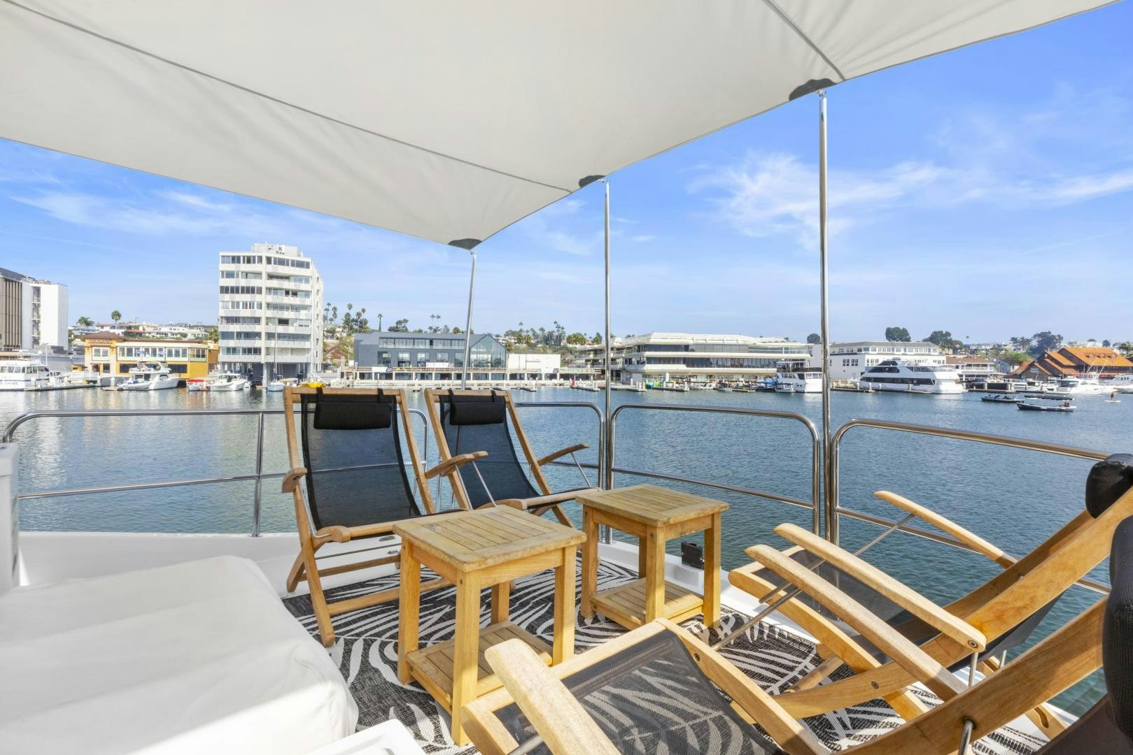 a deck with chairs and tables on it by a body of water aboard RILASSARI Yacht for Sale