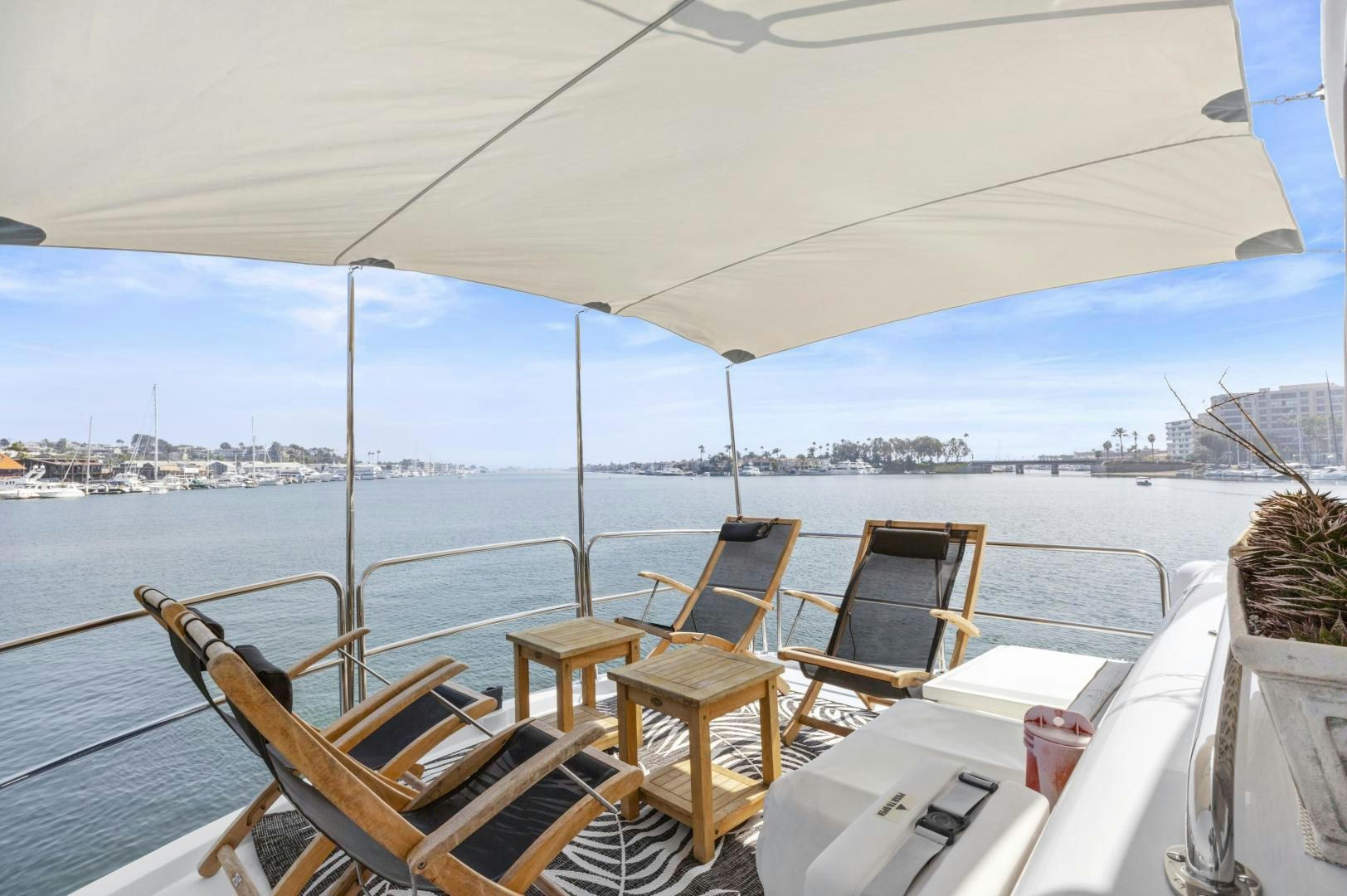 a deck with chairs and tables on it by a body of water aboard RILASSARI Yacht for Sale
