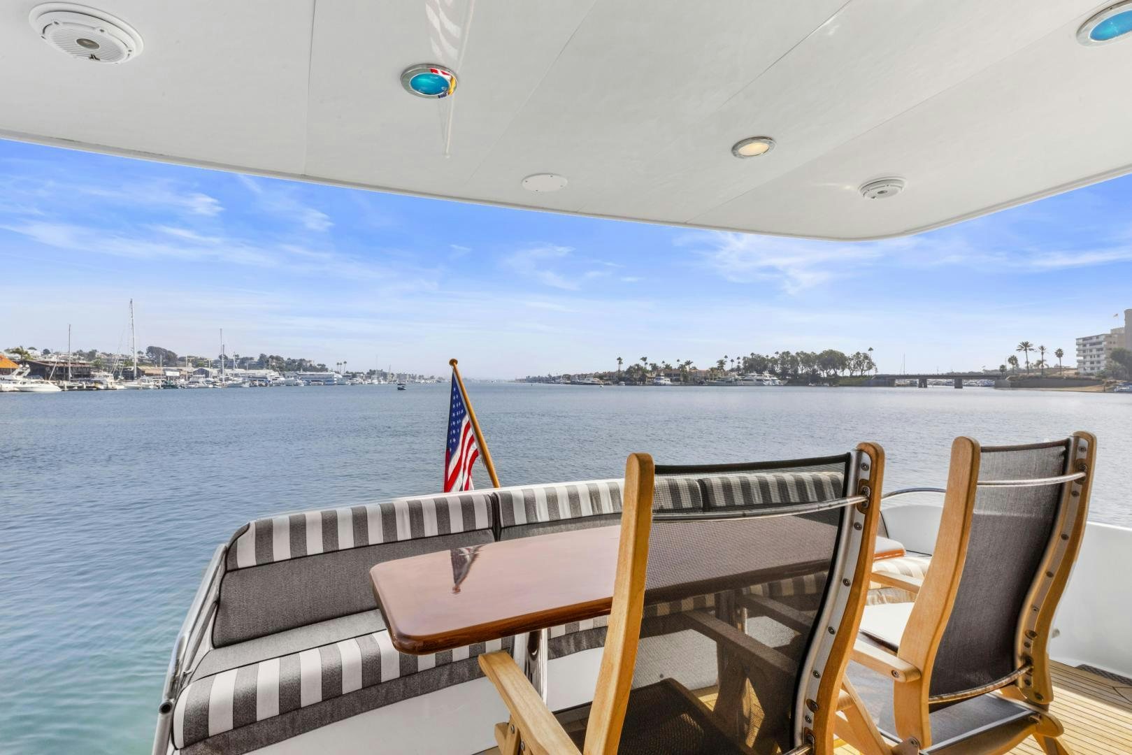 a deck with chairs and a flag on it by a body of water aboard RILASSARI Yacht for Sale