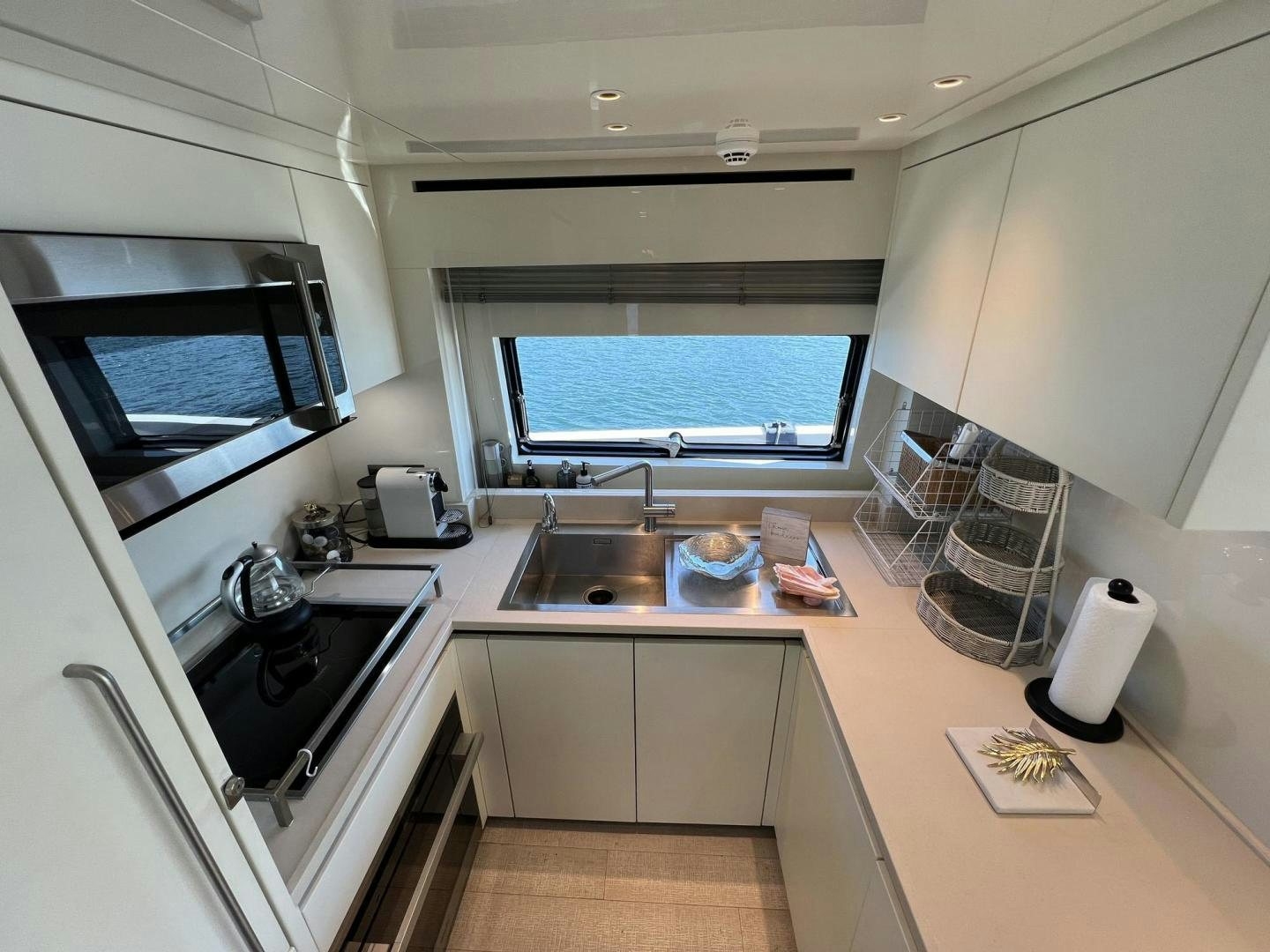 a kitchen with a sink and a microwave aboard Twenty One Yacht for Sale