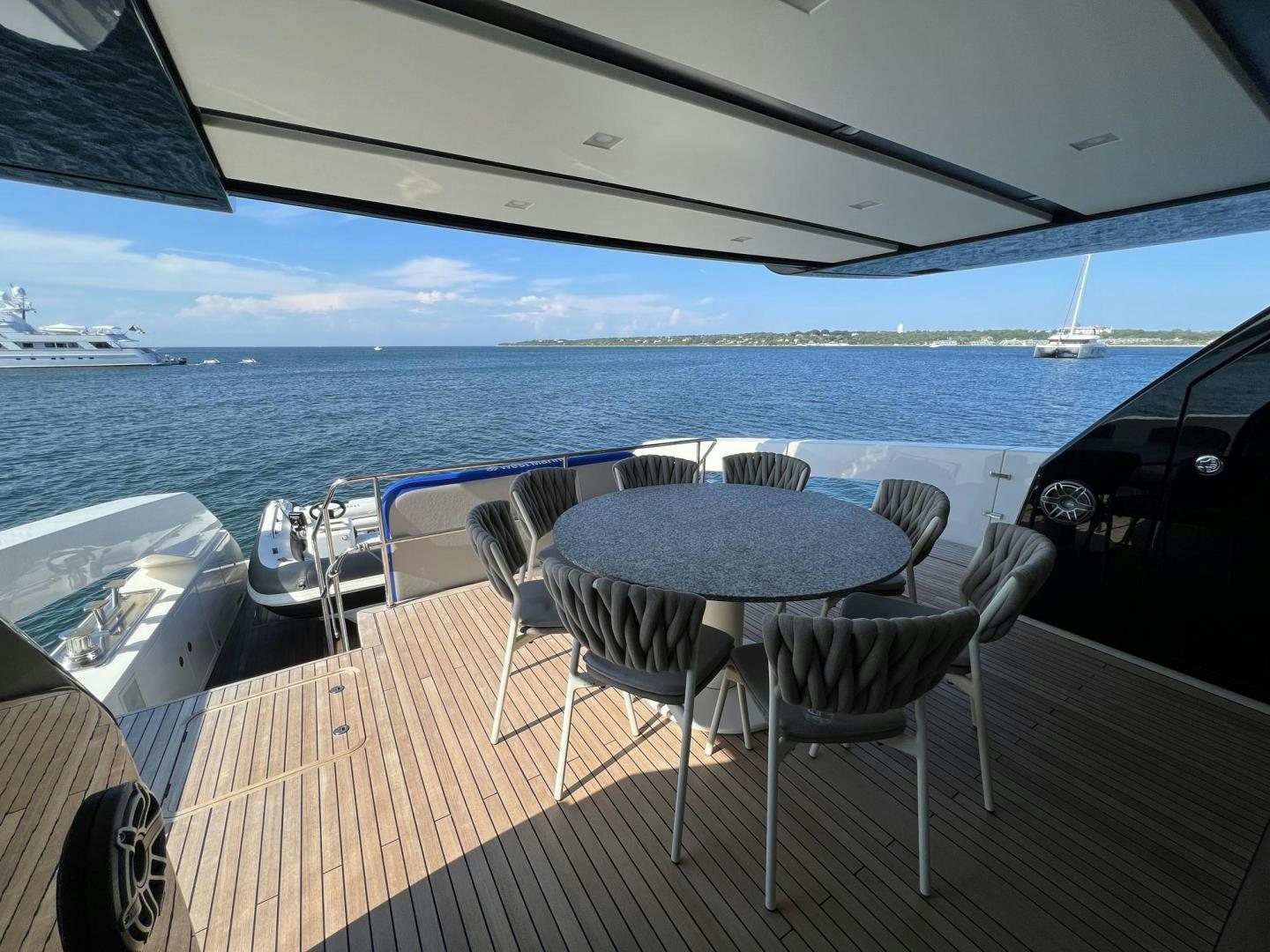 a table and chairs on a deck overlooking a body of water aboard Twenty One Yacht for Sale