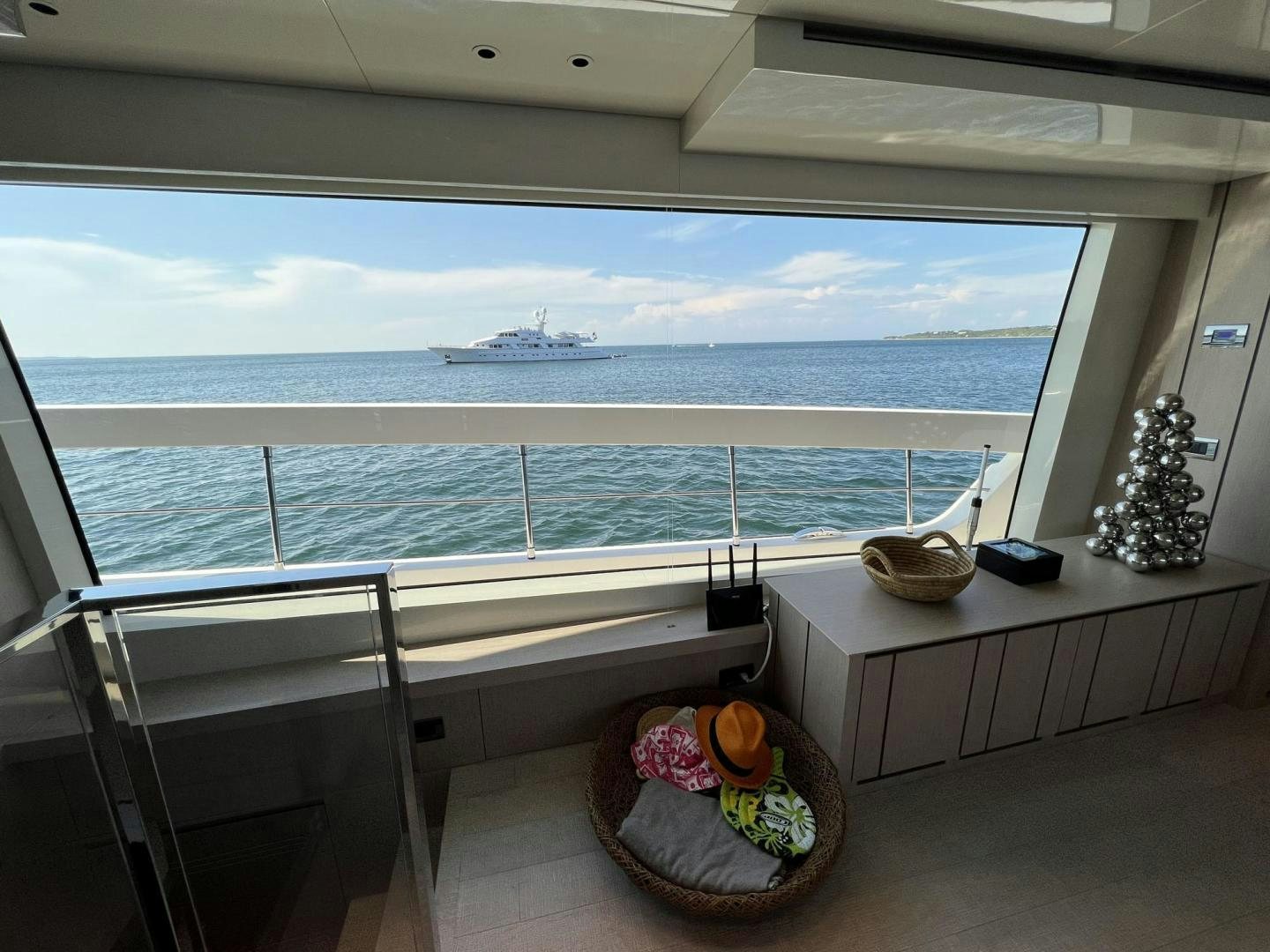 a room with a view of the ocean and a large ship in the distance aboard Twenty One Yacht for Sale