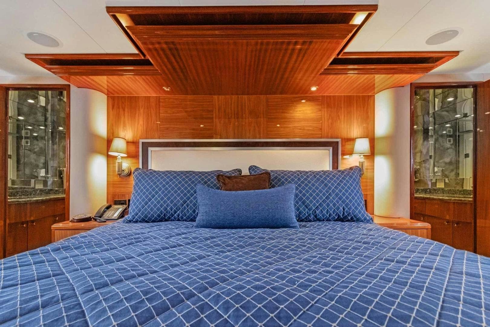 a bed with a blue comforter aboard SEMPER FI Yacht for Sale