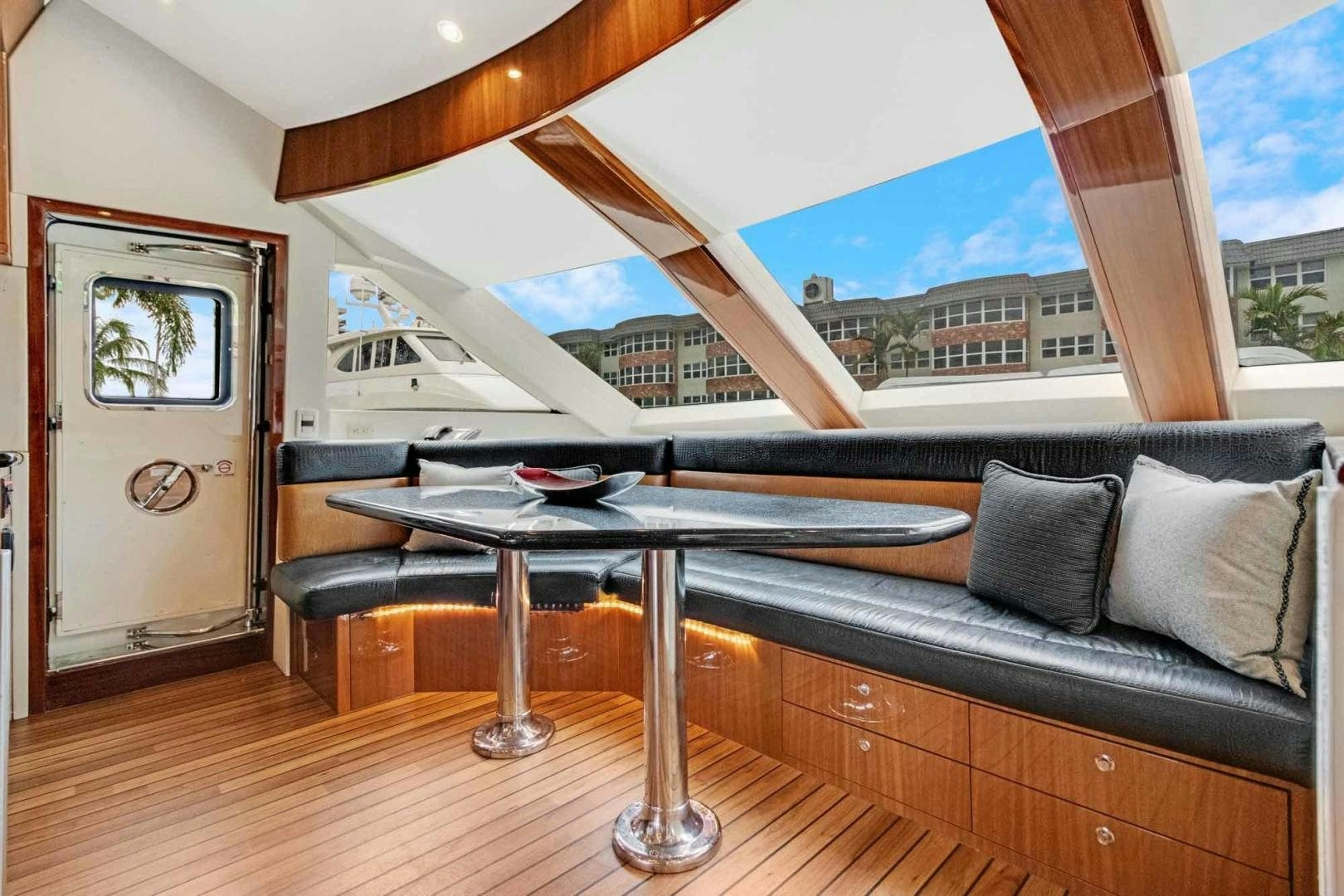 a table and a couch in a room with a window aboard SEMPER FI Yacht for Sale
