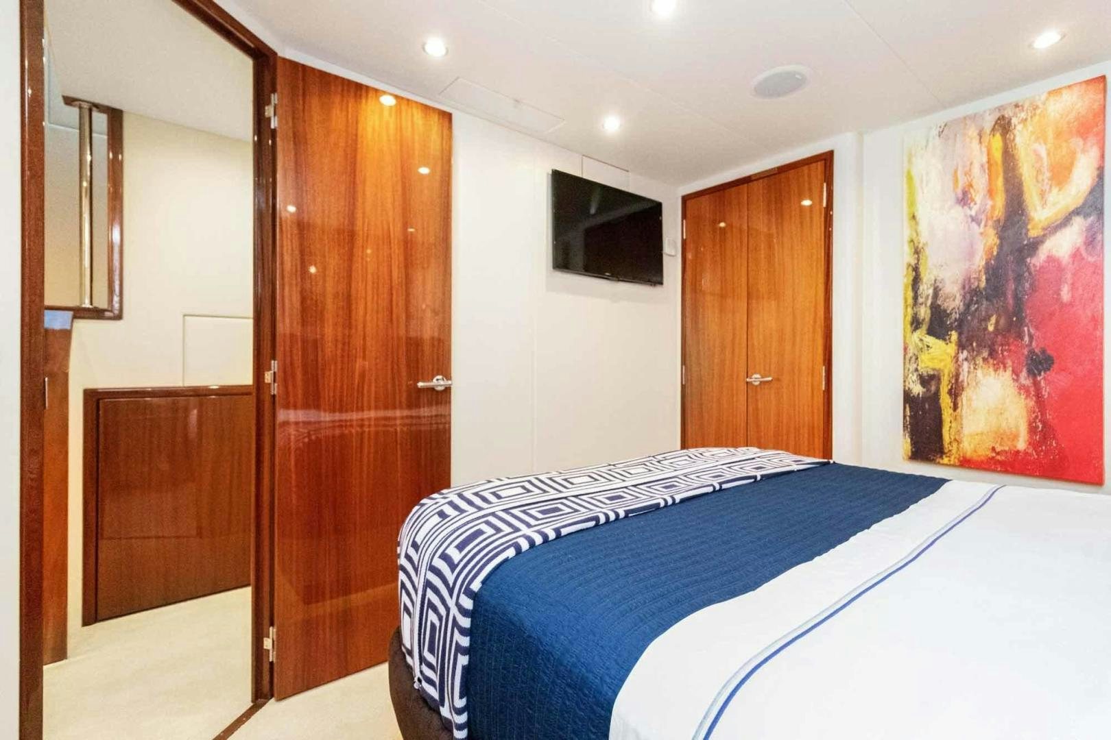 a bedroom with a bed and a wood door aboard SEMPER FI Yacht for Sale