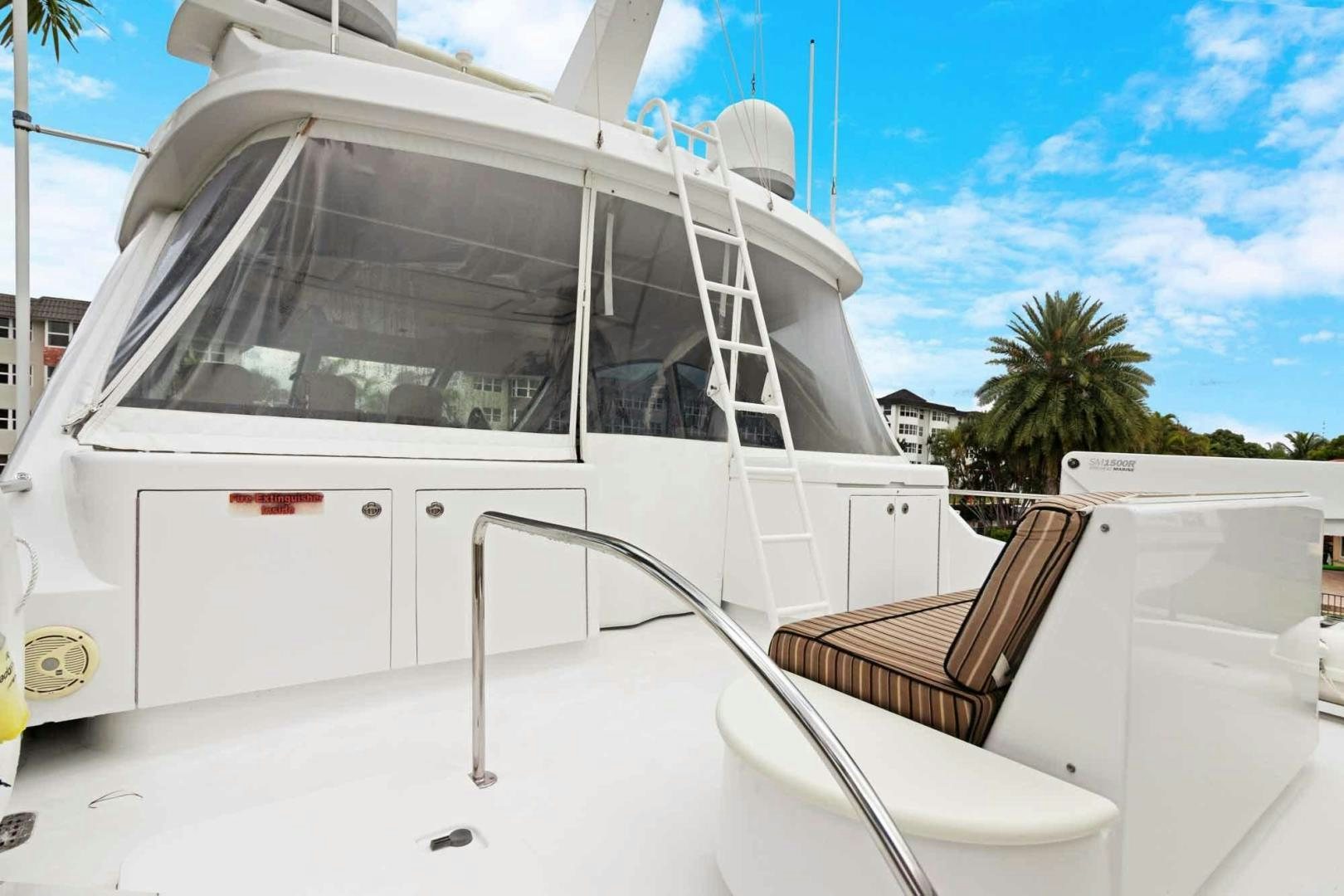 a white boat with a chair on the deck aboard SEMPER FI Yacht for Sale