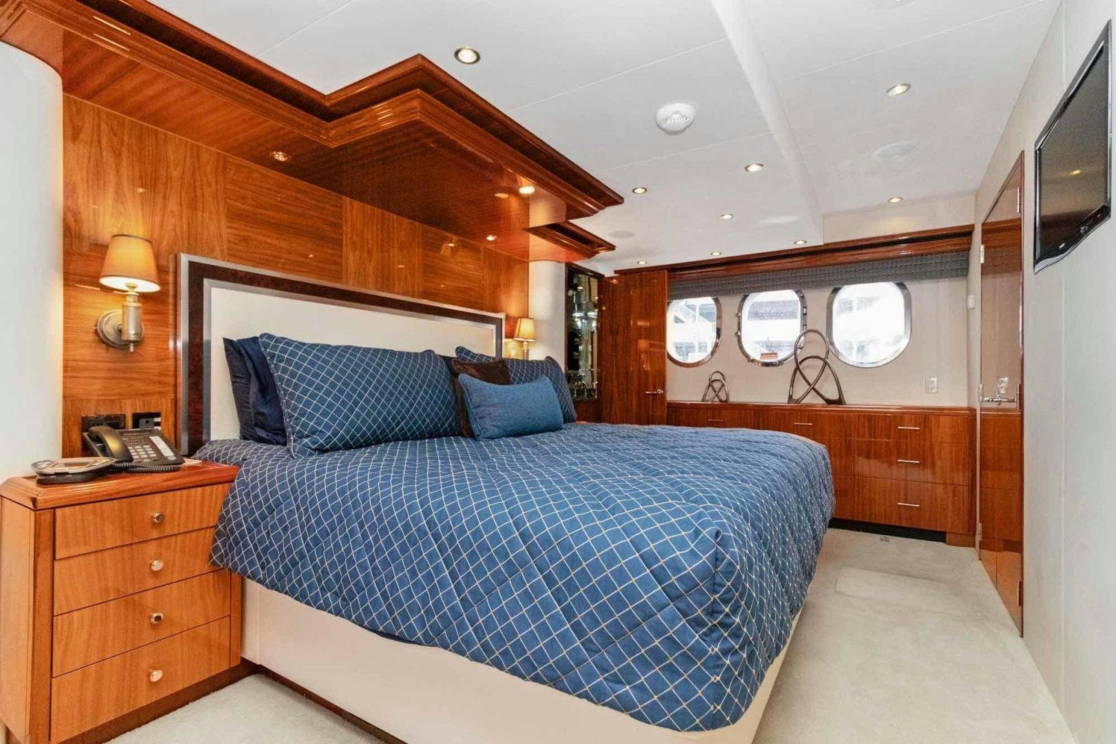 a bedroom with a bed and a dresser aboard SEMPER FI Yacht for Sale