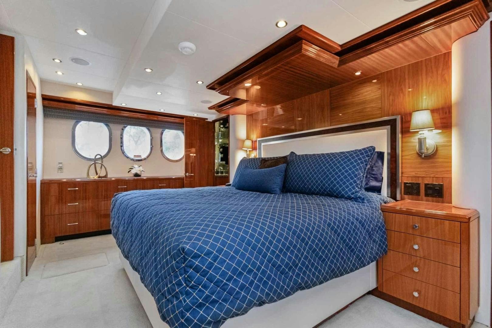 a bedroom with a bed and a dresser aboard SEMPER FI Yacht for Sale