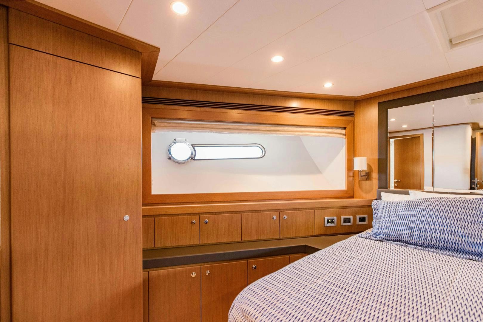 a bedroom with a bed and a wood cabinet aboard SHE RUNS WET Yacht for Sale