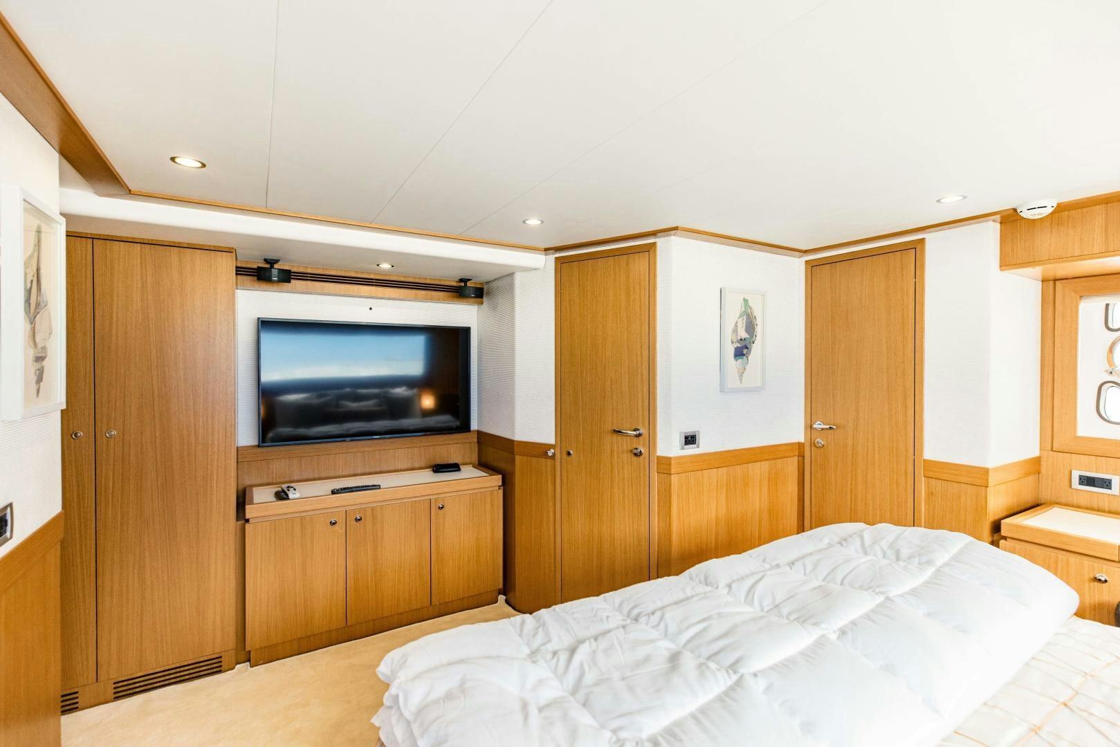 a bedroom with a television and wooden cabinets aboard SHE RUNS WET Yacht for Sale