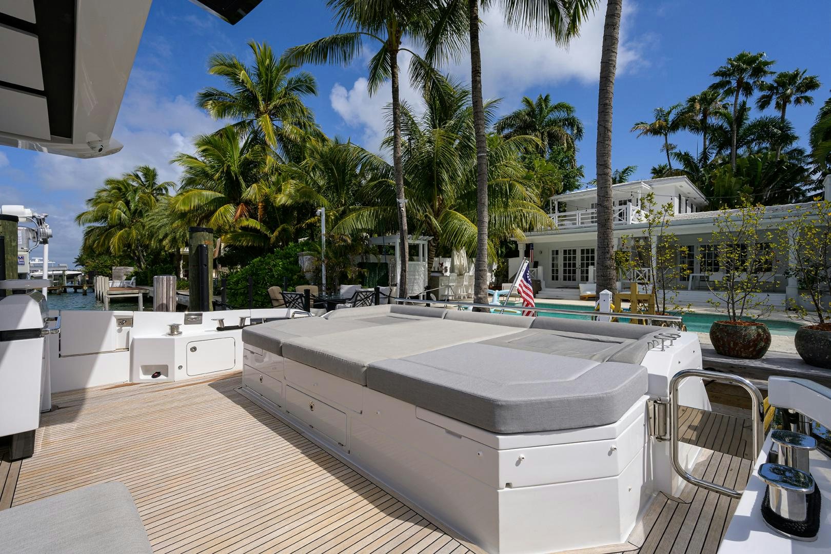 a large pool with a deck and palm trees aboard CRIMSON Yacht for Sale