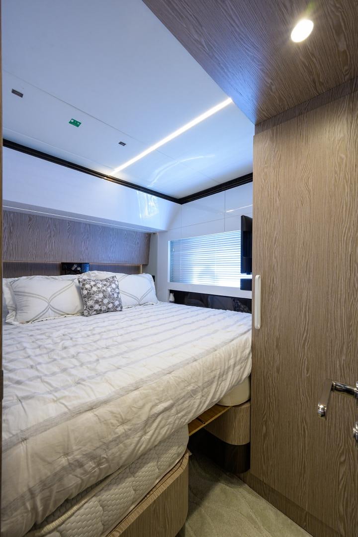 a bedroom with a bed and a window aboard CRIMSON Yacht for Sale