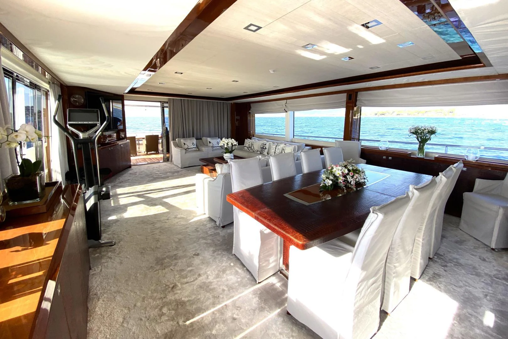 a large living room with a large table and chairs aboard M/Y FLY Yacht for Sale