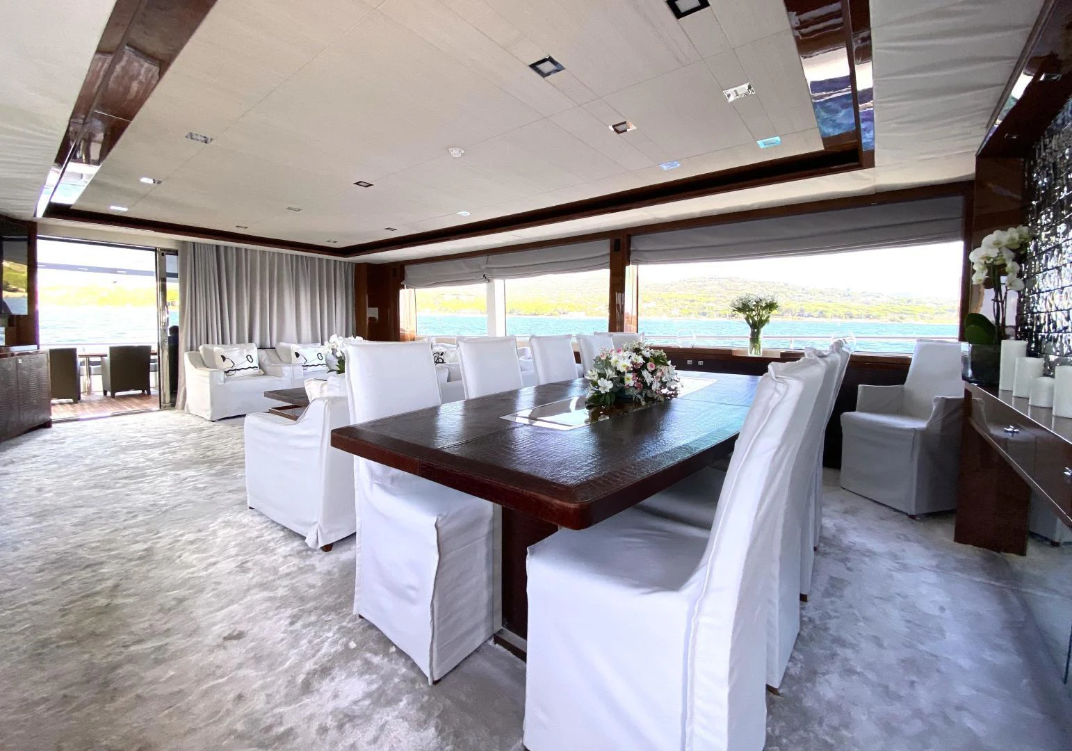 a room with a table chairs and a large window aboard M/Y FLY Yacht for Sale