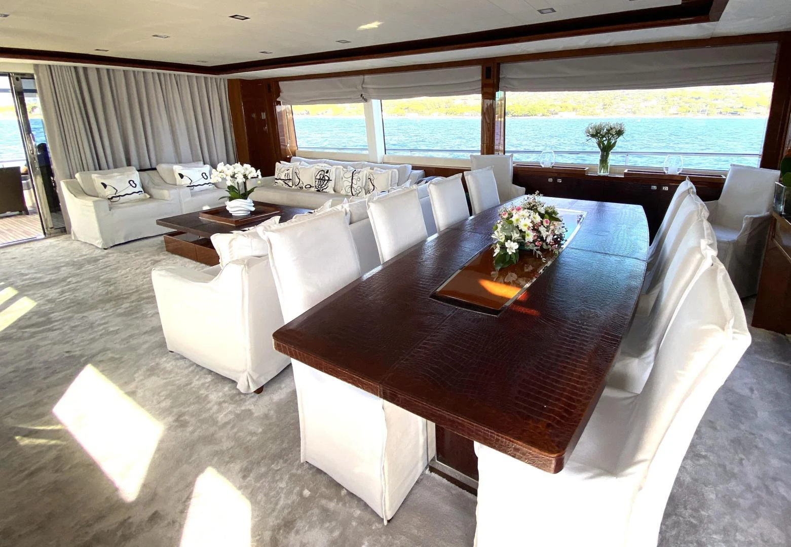 a large living room with a large table and chairs aboard M/Y FLY Yacht for Sale