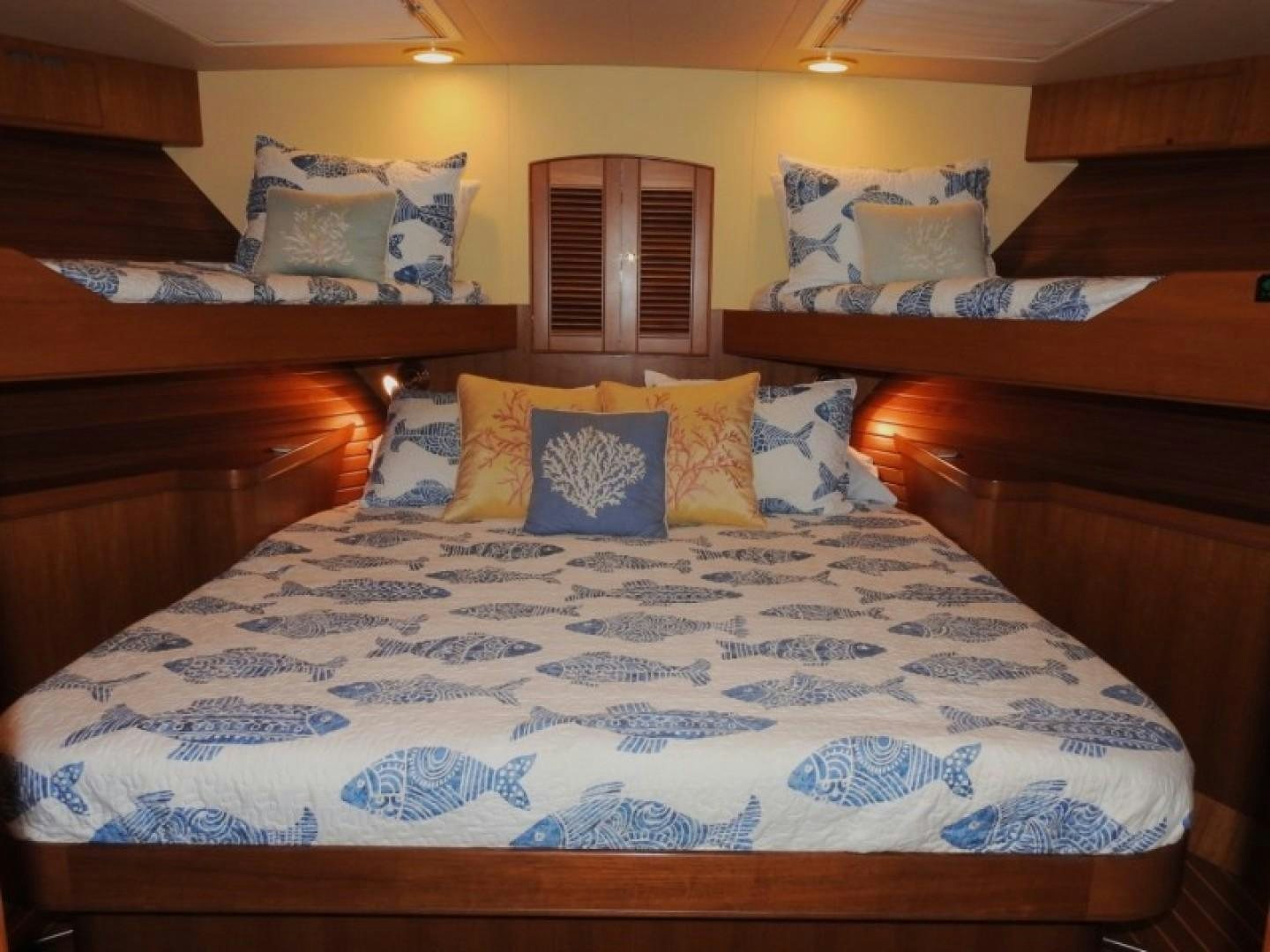 a bed with blue and white sheets aboard AGAVE Yacht for Sale