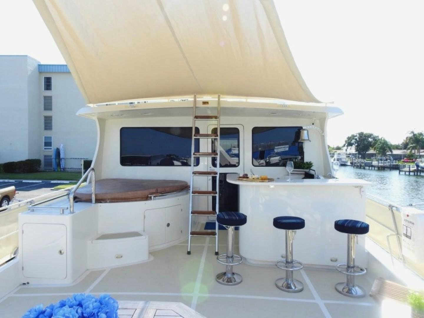 a room with a table and stools and a ladder aboard AGAVE Yacht for Sale