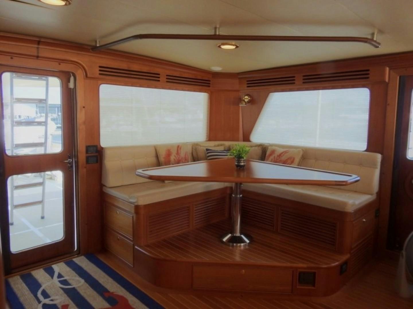 a room with a table and a couch aboard AGAVE Yacht for Sale
