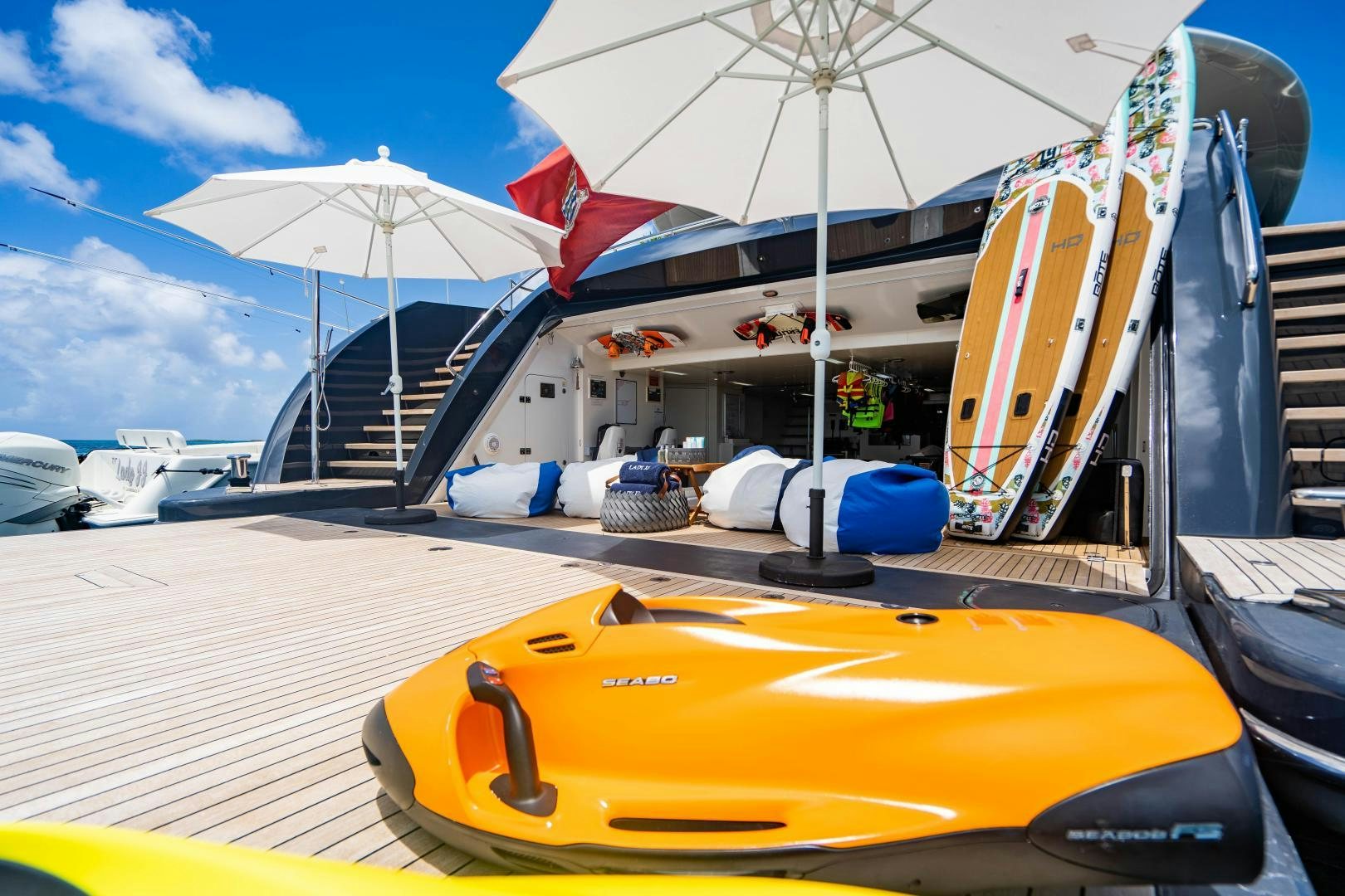 a yellow and white kayak on a deck with a white umbrella aboard SOUTH Yacht for Sale