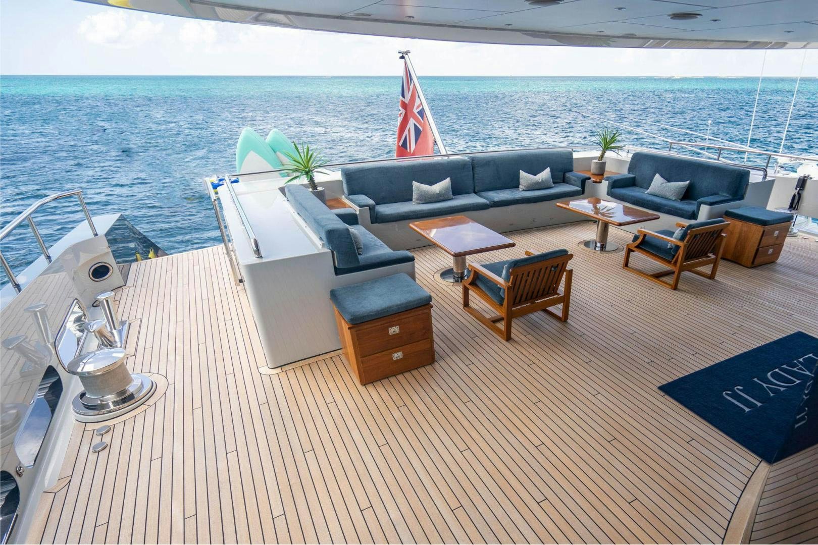 a deck with a couch and a table and chairs on it aboard SOUTH Yacht for Sale