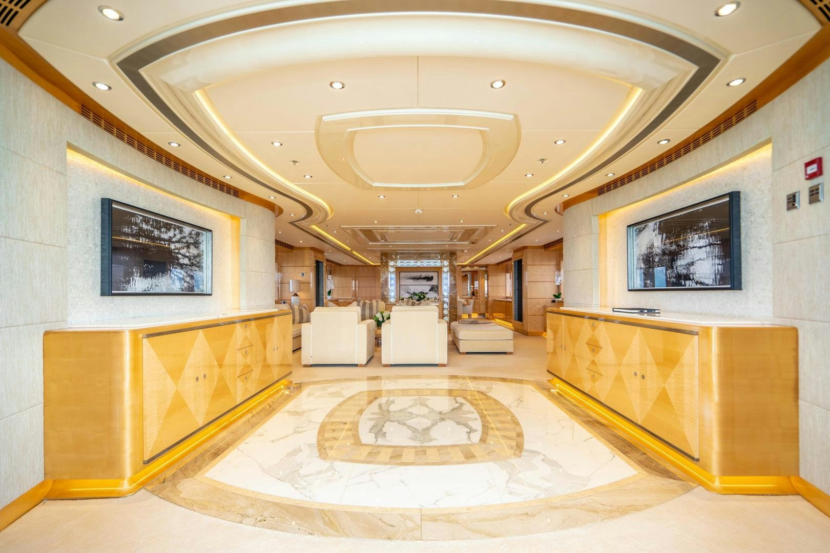 a large room with a large white rug and a large chandelier aboard SOUTH Yacht for Sale