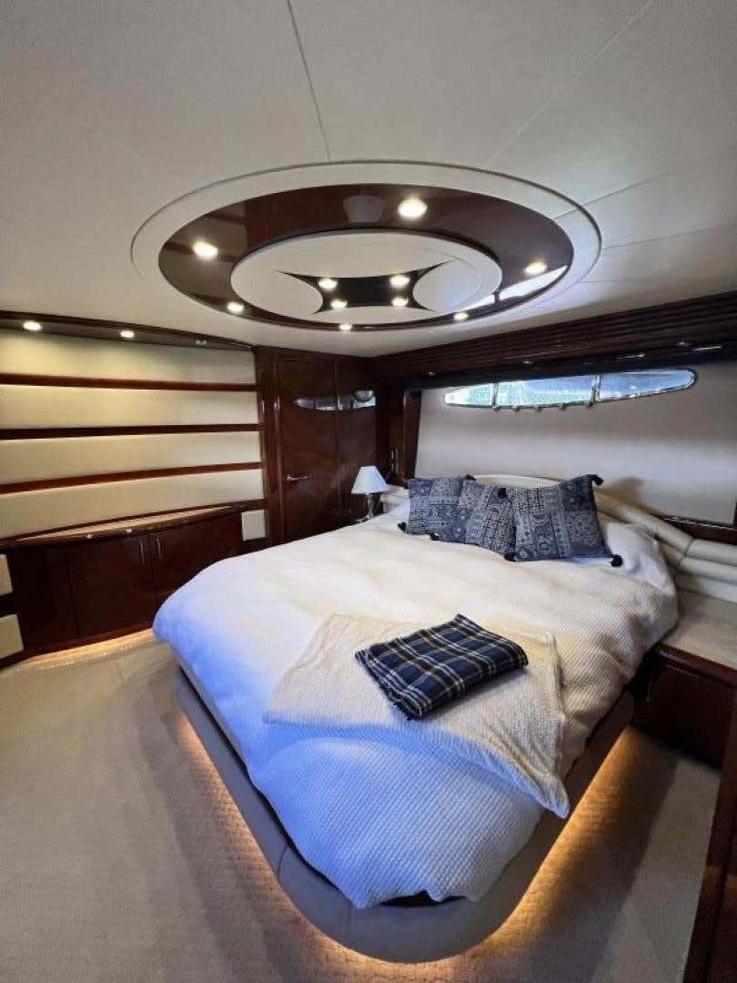 a bed with a blue and white comforter and a round ceiling aboard Casablanca II Yacht for Sale