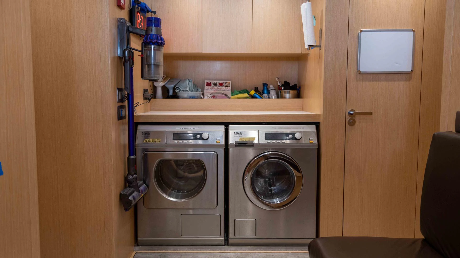 a room with a washer and dryer and a shelf with a chair and a door and aboard FREDDY Yacht for Sale