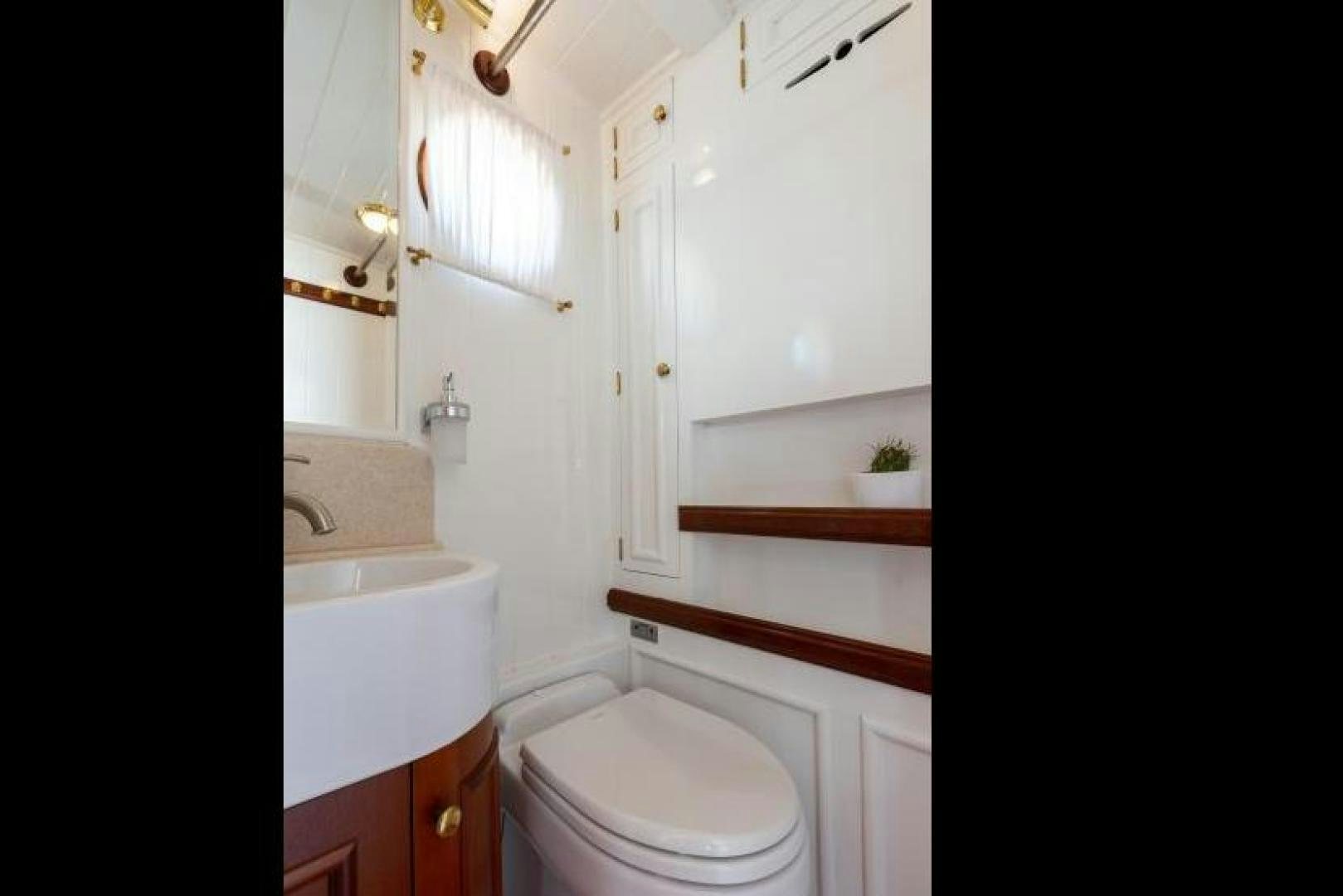 a bathroom with a toilet sink and a mirror aboard NAEMA Yacht for Sale