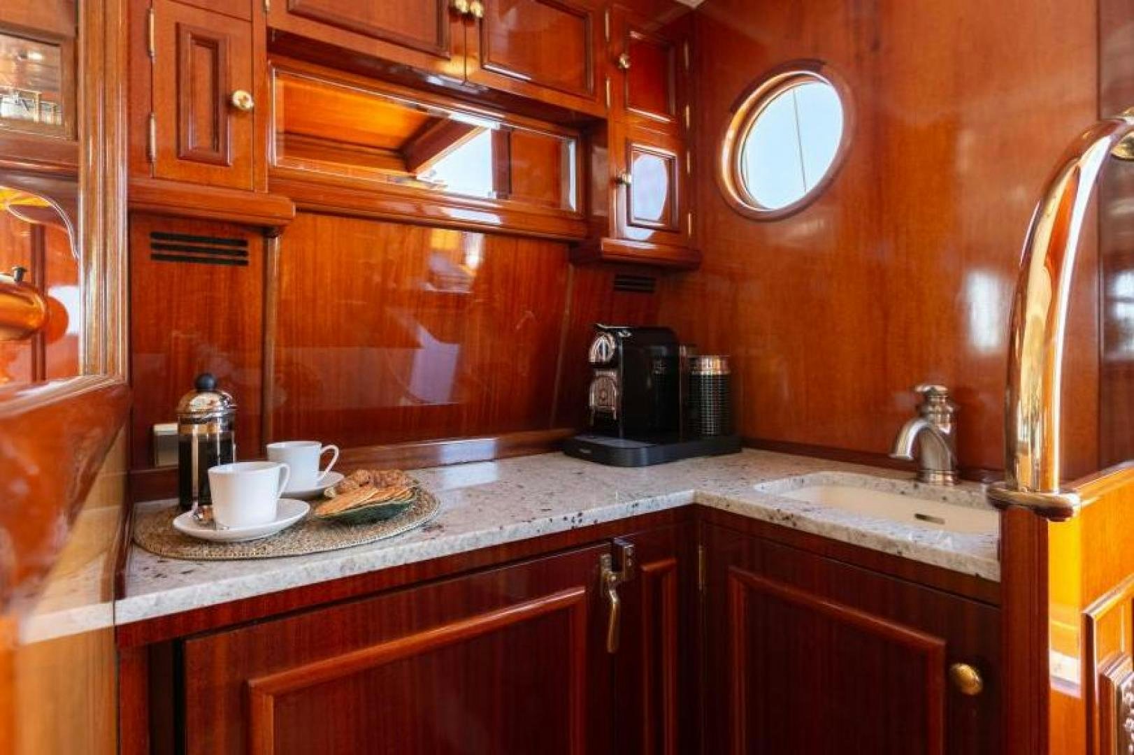 a kitchen with wooden cabinets aboard NAEMA Yacht for Sale