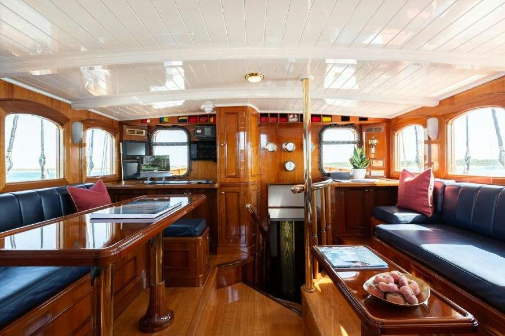 a cabin with a table and couch aboard NAEMA Yacht for Sale