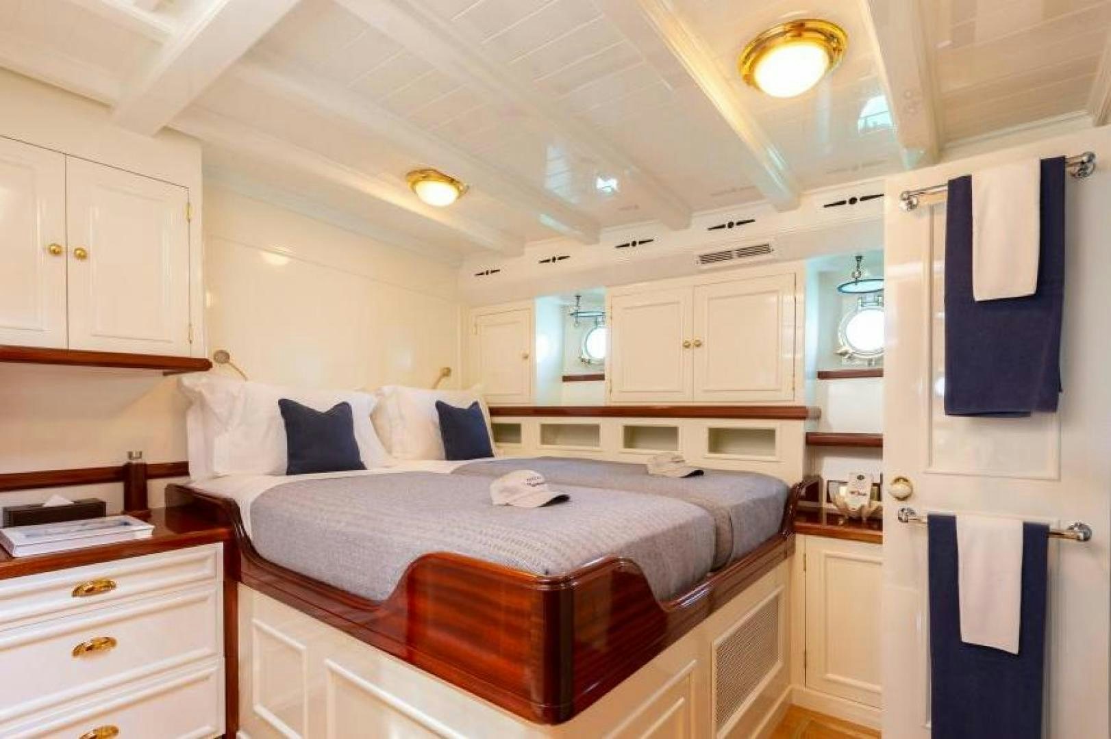a bedroom with a bed and cabinets aboard NAEMA Yacht for Sale