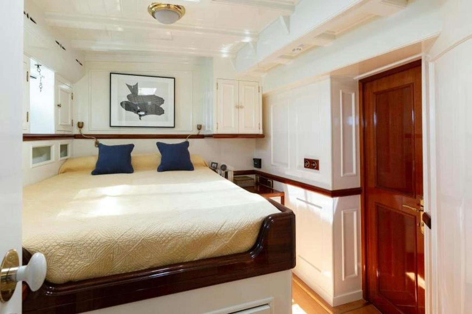 a bedroom with a bed and cabinets aboard NAEMA Yacht for Sale