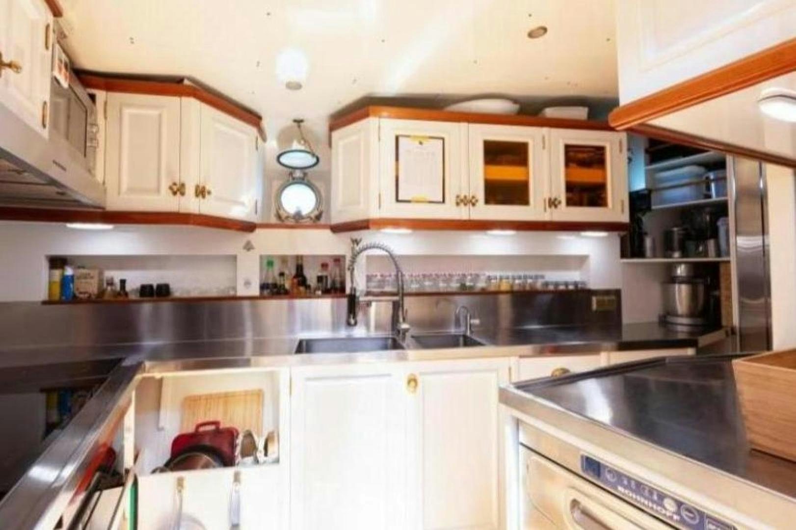 a kitchen with white cabinets aboard NAEMA Yacht for Sale