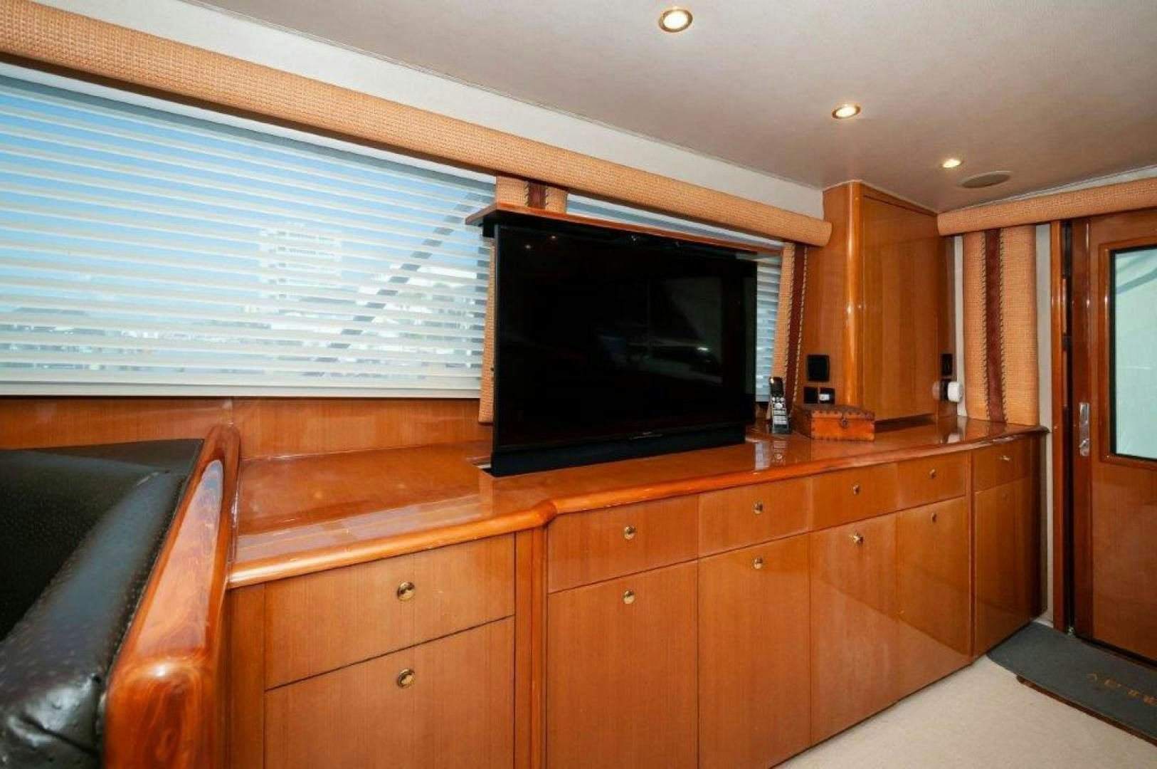 a room with wooden cabinets and a tv on the wall aboard MISS PAULA V Yacht for Sale