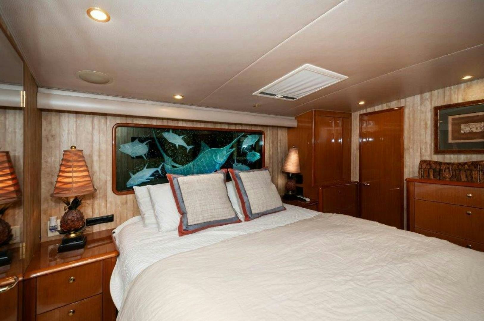 a bedroom with a bed and a lamp aboard MISS PAULA V Yacht for Sale