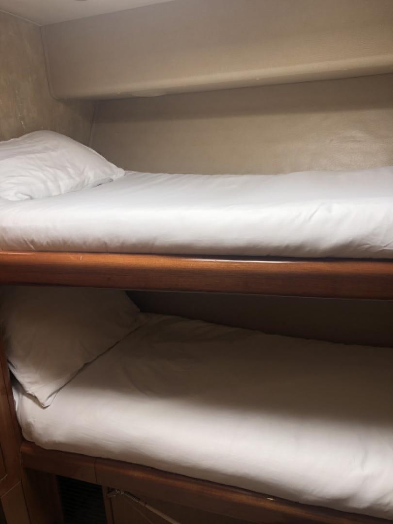 a bed with white sheets aboard MISS PAULA V Yacht for Sale