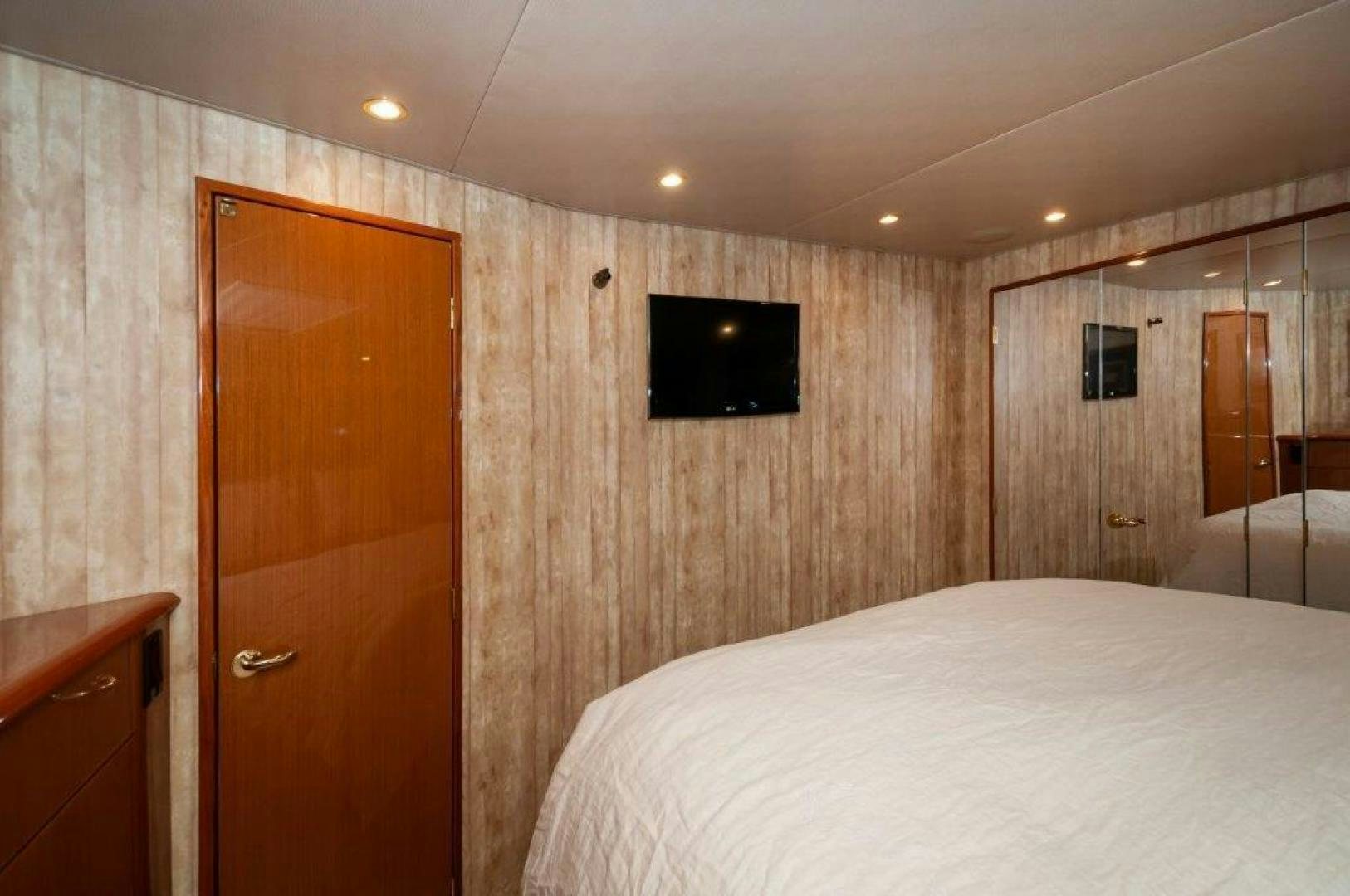 a bedroom with a bed and a television on the wall aboard MISS PAULA V Yacht for Sale