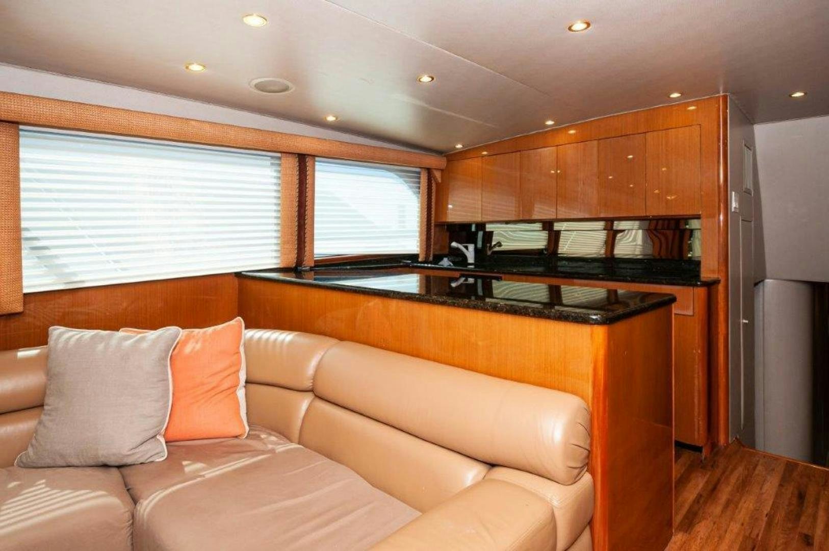 a living room with a couch and a kitchen in the background aboard MISS PAULA V Yacht for Sale